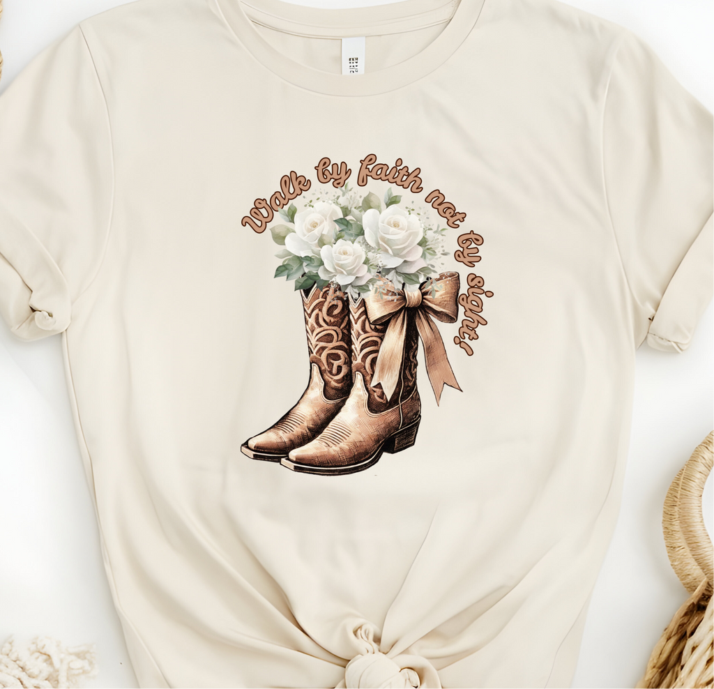 Faith Based Woman’s T-Shirt Featuring Cowgirl boots, White Flowers and The Message “Walk by faith not by sight!”