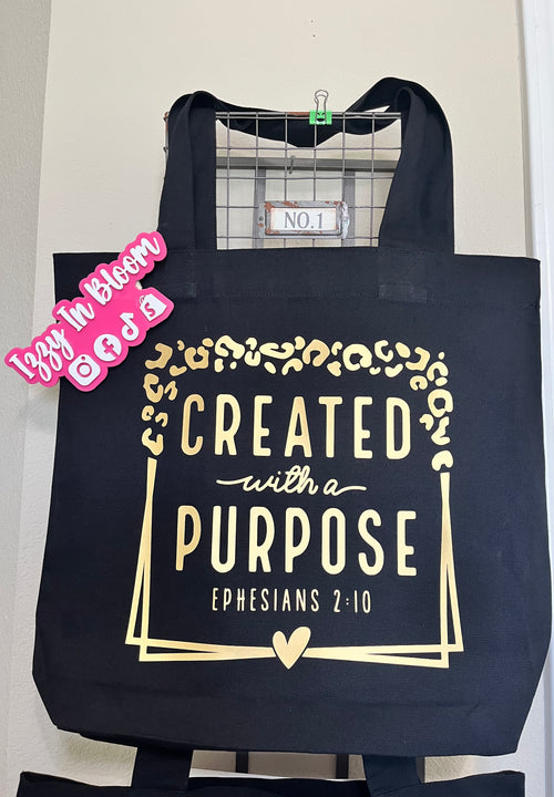 Black 16x15X3 100% Cotton Tote Bag featuring the message “Created With A Purpose” along with the Biblical Scripture Ephesians 2:10.