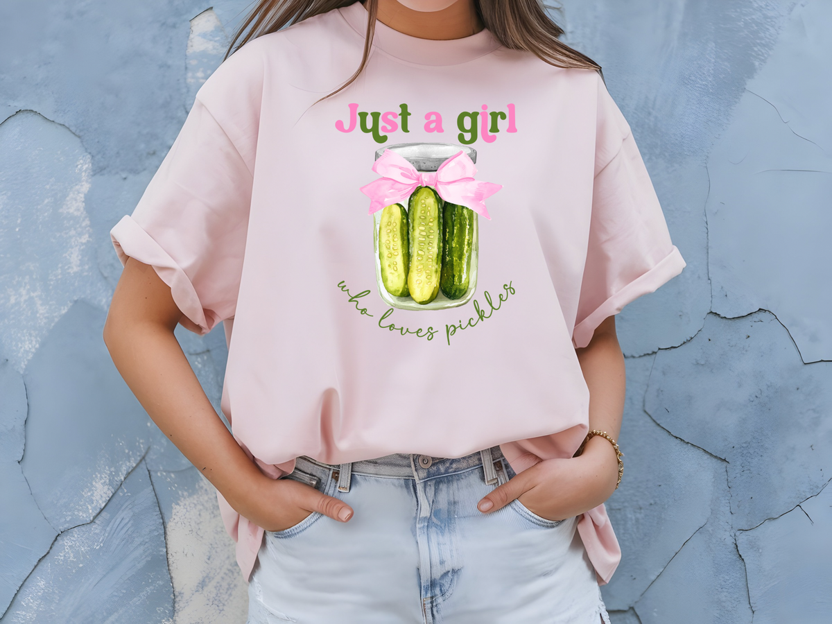 Pickle Inspired Woman’s T-Shirt Featuring A Pink Coquette Bow, Pickles and a fun message “Just A Girl Who Loves Pickles”