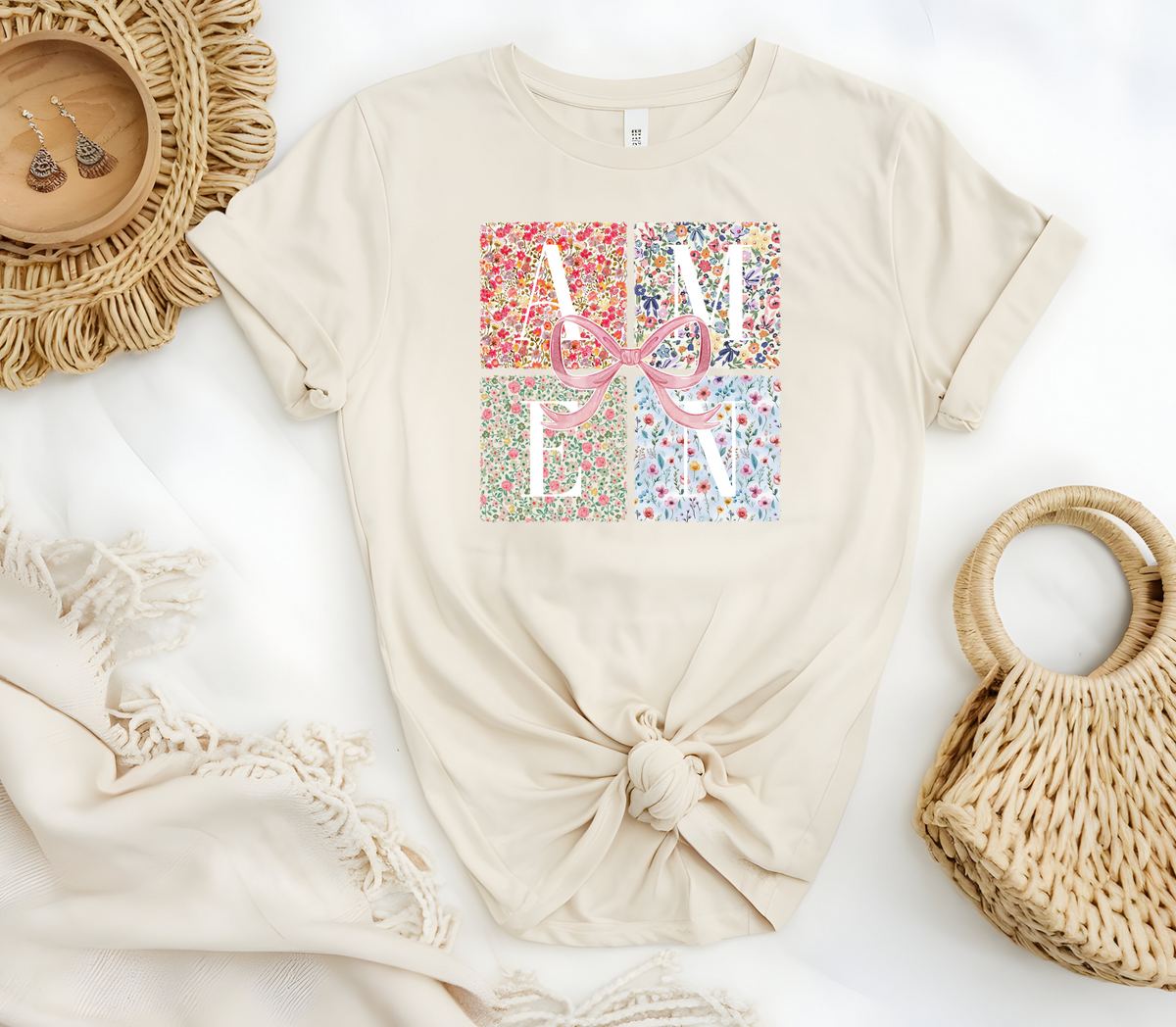 Faith Based Woman’s T-Shirt featuring a pink coquette bow with flower decor and the message “AMEN”