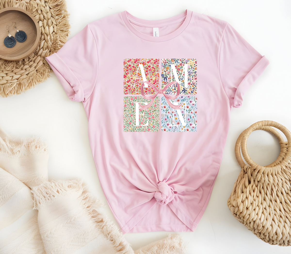 Faith Based Woman’s T-Shirt featuring a pink coquette bow with flower decor and the message “AMEN”