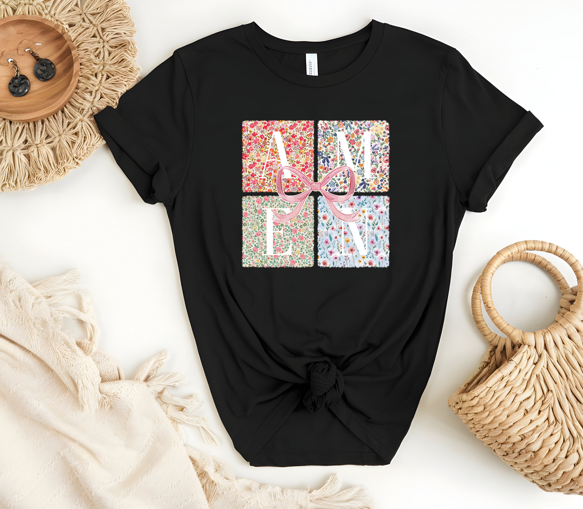 Faith Based Woman’s T-Shirt featuring a pink coquette bow with flower decor and the message “AMEN”