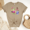 Custom Woman’s T-Shirt featuring, the message “Not Fragile Like A Flower, Fragile Like A Bomb” surrounded by wild flowers, a pink hummingbird and graphic picture of a grenade.