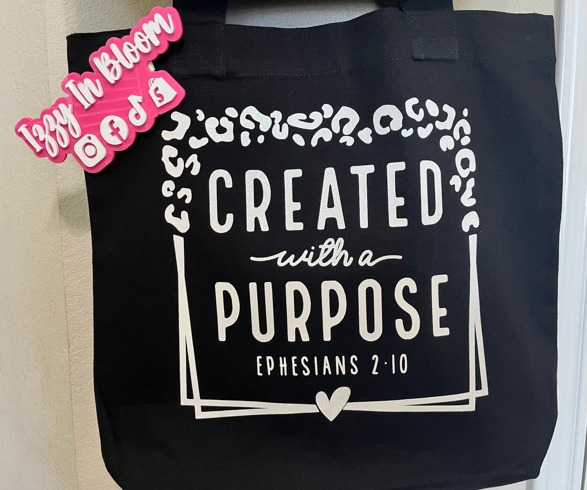 Black 16x15X3 100% Cotton Tote Bag featuring the message “Created With A Purpose” along with the Biblical Scripture Ephesians 2:10.